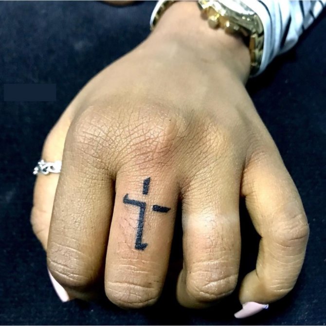 cross on thumb tattoo meaning in the zone