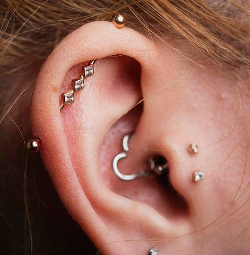 Pierced cartilage in a girl's ear with an earring ring, nail, chain