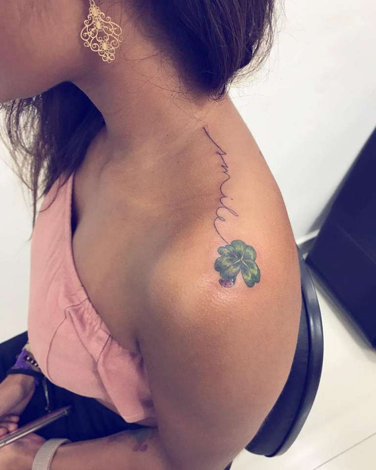 Tattoo of a clover on a girl's shoulder