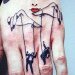 Tattoo of a puppeteer and puppets on the hand