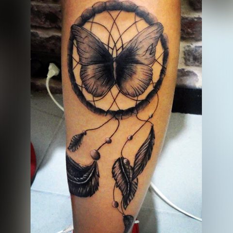 Tattoo of a dream catcher with a butterfly inside