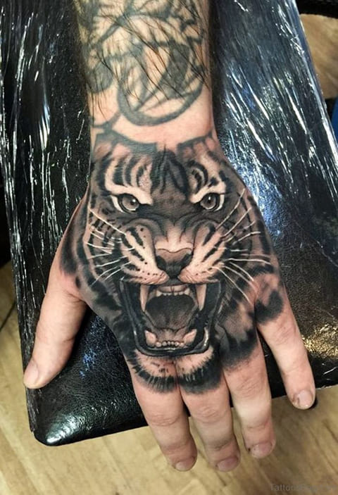 Tattoo of a tiger grinning on his wrist