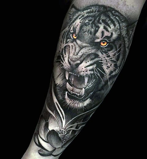 Tattoo of a tiger grinning on his arm