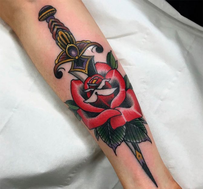 Tattoo rose with a dagger on his arm