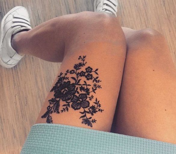 Tattoo in the form of lace with vetami on a girl's leg