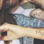 Tattoos on two arms for girls, male on tear, inscriptions. Photo